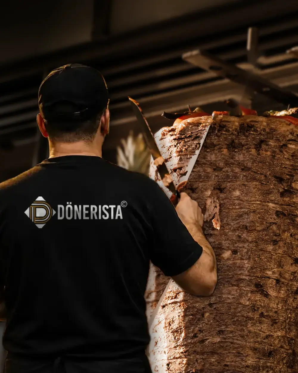 Dönerista Koch schneidet Döner vom Spieß